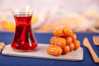 Geleneksel Osmanlı Mutfağı Tatlıları, Tulumba Tatlısı. Tabakta Türk tatlı tülumbası. Tulumba tatlısı, yağda kızartılmış ve şurupla ıslanmış..