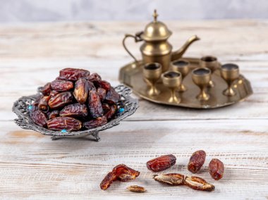 Eski Arap tabağındaki meyveler ya da Kurma ile ahşap arka plandaki su testisi. Hurma ve Zamzam suyu Ramazan yiyeceğidir. Ramazan iftar yiyeceği.