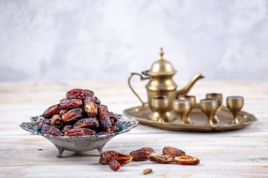 Eski Arap tabağındaki meyveler ya da Kurma ile ahşap arka plandaki su testisi. Hurma ve Zamzam suyu Ramazan yiyeceğidir. Ramazan iftar yiyeceği.