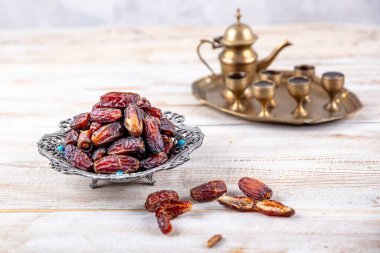 Eski Arap tabağındaki meyveler ya da Kurma ile ahşap arka plandaki su testisi. Hurma ve Zamzam suyu Ramazan yiyeceğidir. Ramazan iftar yiyeceği.