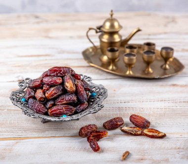 Eski Arap tabağındaki meyveler ya da Kurma ile ahşap arka plandaki su testisi. Hurma ve Zamzam suyu Ramazan yiyeceğidir. Ramazan iftar yiyeceği.