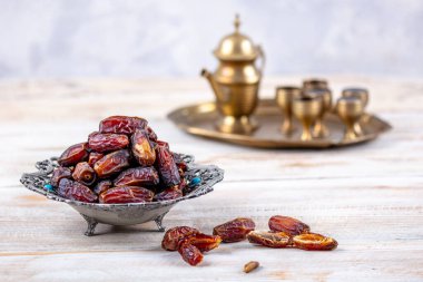 Eski Arap tabağındaki meyveler ya da Kurma ile ahşap arka plandaki su testisi. Hurma ve Zamzam suyu Ramazan yiyeceğidir. Ramazan iftar yiyeceği.