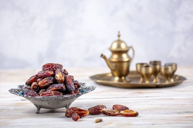 Eski Arap tabağındaki meyveler ya da Kurma ile ahşap arka plandaki su testisi. Hurma ve Zamzam suyu Ramazan yiyeceğidir. Ramazan iftar yiyeceği.