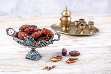 Eski Arap tabağındaki meyveler ya da Kurma ile ahşap arka plandaki su testisi. Hurma ve Zamzam suyu Ramazan yiyeceğidir. Ramazan iftar yiyeceği.
