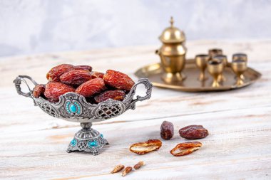 Eski Arap tabağındaki meyveler ya da Kurma ile ahşap arka plandaki su testisi. Hurma ve Zamzam suyu Ramazan yiyeceğidir. Ramazan iftar yiyeceği.