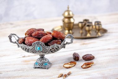 Eski Arap tabağındaki meyveler ya da Kurma ile ahşap arka plandaki su testisi. Hurma ve Zamzam suyu Ramazan yiyeceğidir. Ramazan iftar yiyeceği.