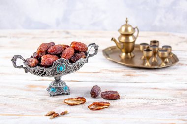 Eski Arap tabağındaki meyveler ya da Kurma ile ahşap arka plandaki su testisi. Hurma ve Zamzam suyu Ramazan yiyeceğidir. Ramazan iftar yiyeceği.