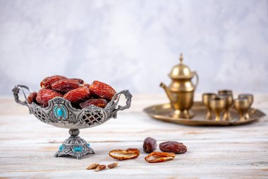 Eski Arap tabağındaki meyveler ya da Kurma ile ahşap arka plandaki su testisi. Hurma ve Zamzam suyu Ramazan yiyeceğidir. Ramazan iftar yiyeceği.