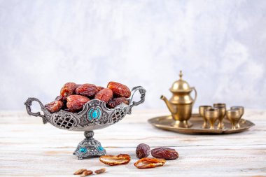 Eski Arap tabağındaki meyveler ya da Kurma ile ahşap arka plandaki su testisi. Hurma ve Zamzam suyu Ramazan yiyeceğidir. Ramazan iftar yiyeceği.