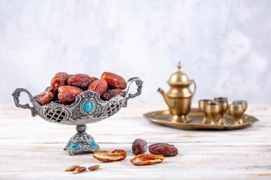 Eski Arap tabağındaki meyveler ya da Kurma ile ahşap arka plandaki su testisi. Hurma ve Zamzam suyu Ramazan yiyeceğidir. Ramazan iftar yiyeceği.