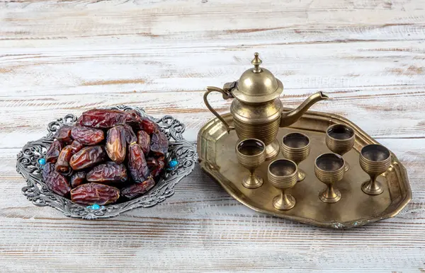 Eski Arap tabağındaki meyveler ya da Kurma ile ahşap arka plandaki su testisi. Hurma ve Zamzam suyu Ramazan yiyeceğidir. Ramazan iftar yiyeceği.