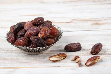 Tahta arka planda eski gümüş tabakta meyve ve zamzam suyu var. Ramazan iftar yemeği. Kurumuş tarihli Ramazan kareemi ve orjinal metal zamzam su testisi, kutsal ay konsepti..