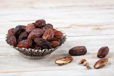 Tahta arka planda eski gümüş tabakta meyve ve zamzam suyu var. Ramazan iftar yemeği. Kurumuş tarihli Ramazan kareemi ve orjinal metal zamzam su testisi, kutsal ay konsepti..