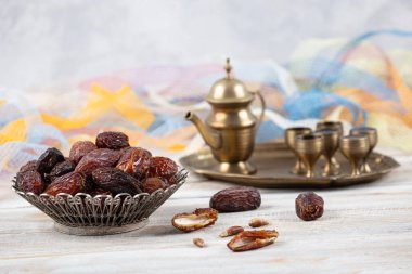 Tahta arka planda eski gümüş tabakta meyve ve zamzam suyu var. Ramazan iftar yemeği. Kurumuş tarihli Ramazan kareemi ve orjinal metal zamzam su testisi, kutsal ay konsepti..