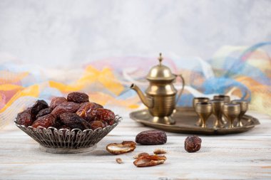 Tahta arka planda eski gümüş tabakta meyve ve zamzam suyu var. Ramazan iftar yemeği. Kurumuş tarihli Ramazan kareemi ve orjinal metal zamzam su testisi, kutsal ay konsepti..