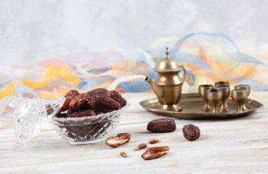 Tahta arka planda eski gümüş tabakta meyve ve zamzam suyu var. Ramazan iftar yemeği. Kurumuş tarihli Ramazan kareemi ve orjinal metal zamzam su testisi, kutsal ay konsepti..