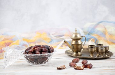 Tahta arka planda eski gümüş tabakta meyve ve zamzam suyu var. Ramazan iftar yemeği. Kurumuş tarihli Ramazan kareemi ve orjinal metal zamzam su testisi, kutsal ay konsepti..