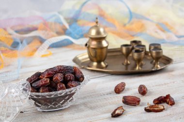 Tahta arka planda eski gümüş tabakta meyve ve zamzam suyu var. Ramazan iftar yemeği. Kurumuş tarihli Ramazan kareemi ve orjinal metal zamzam su testisi, kutsal ay konsepti..