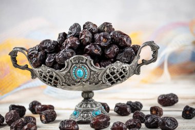 Acve hurma meyvesi, ahşap arka planda eski gümüş tabakta Acve palmiye meyvesi. Kurumuş meyve Ramazan Kareem, kutsal ay Ramazan kavramı.