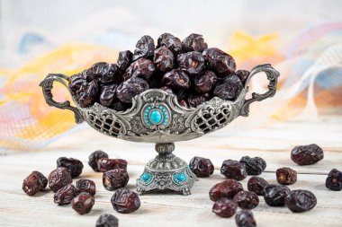 Acve hurma meyvesi, ahşap arka planda eski gümüş tabakta Acve palmiye meyvesi. Kurumuş meyve Ramazan Kareem, kutsal ay Ramazan kavramı.