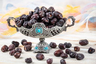 Acve hurma meyvesi, ahşap arka planda eski gümüş tabakta Acve palmiye meyvesi. Kurumuş meyve Ramazan Kareem, kutsal ay Ramazan kavramı.