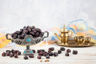 Acve hurma meyvesi, ahşap arka planda eski gümüş tabakta Acve palmiye meyvesi. Kurumuş meyve Ramazan Kareem, kutsal ay Ramazan kavramı.