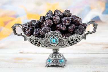 Acve hurma meyvesi, ahşap arka planda eski gümüş tabakta Acve palmiye meyvesi. Kurumuş meyve Ramazan Kareem, kutsal ay Ramazan kavramı.