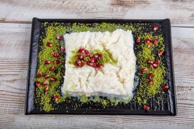 Geleneksel Türk Ramazan Tatlısı Gullac masada. Gullac, süt, gül suyu, ceviz, vanilya. Nar ve şam fıstığı ile süslenmiş. Osmanlı mutfağından tatlı.