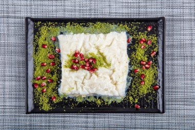 Geleneksel Türk Ramazan Tatlısı Gullac masada. Gullac, süt, gül suyu, ceviz, vanilya. Nar ve şam fıstığı ile süslenmiş. Osmanlı mutfağından tatlı.