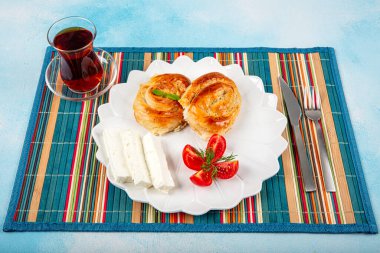 Geleneksel lezzetli peynirli Türk burek (Türk adı: Gül borek) Peynir, domates ve bir bardak çayla servis edilen peynirli hamur işi