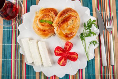 Geleneksel lezzetli peynirli Türk burek (Türk adı: Gül borek) Peynir, domates ve bir bardak çayla servis edilen peynirli hamur işi