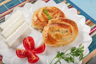 Traditional delicious Turkish burek with cheese (Turkish name; Gul borek ) Rose shaped pastry with cheese served with cheese ,tomatoe and a glass of tea clipart