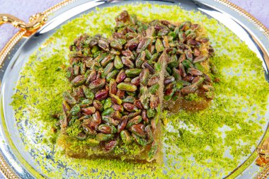 Şam fıstıklı kadayif. Şerbetli Kadayif tatlısı, tepside şam fıstığı, ahşap bir arka planda rendelenmiş yufka. Geleneksel Türk tatlısının yerel adı fistikzade kadayif.