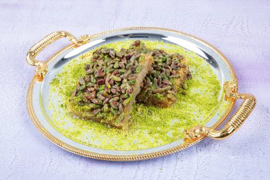 Şam fıstıklı kadayif. Şerbetli Kadayif tatlısı, tepside şam fıstığı, ahşap bir arka planda rendelenmiş yufka. Geleneksel Türk tatlısının yerel adı fistikzade kadayif.