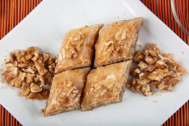 Geleneksel Türk tatlıları; el yapımı ceviz baklavası. Türkçe adı: cevizli baklava. Ahşap zemin üzerinde ceviz baklava. Türk tarzı ceviz baklavası sunumu ve hizmeti.
