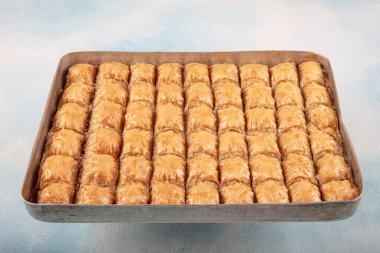 Geleneksel Türk tatlıları; el yapımı ceviz baklavası. Türkçe adı: cevizli baklava. Ahşap zemin üzerinde ceviz baklava. Türk tarzı ceviz baklavası sunumu ve hizmeti.