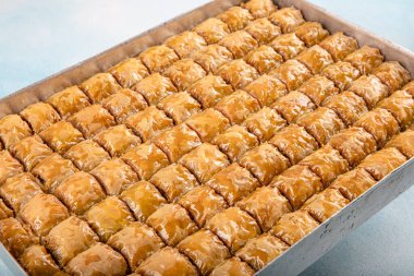 Geleneksel Türk tatlıları; el yapımı ceviz baklavası. Türkçe adı: cevizli baklava. Ahşap zemin üzerinde ceviz baklava. Türk tarzı ceviz baklavası sunumu ve hizmeti.