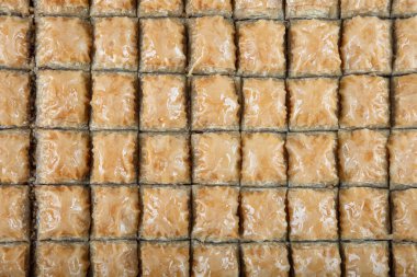 Geleneksel Türk tatlıları; el yapımı ceviz baklavası. Türkçe adı: cevizli baklava. Ahşap zemin üzerinde ceviz baklava. Türk tarzı ceviz baklavası sunumu ve hizmeti.