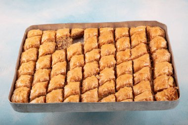 Geleneksel Türk tatlıları; el yapımı ceviz baklavası. Türkçe adı: cevizli baklava. Ahşap zemin üzerinde ceviz baklava. Türk tarzı ceviz baklavası sunumu ve hizmeti.