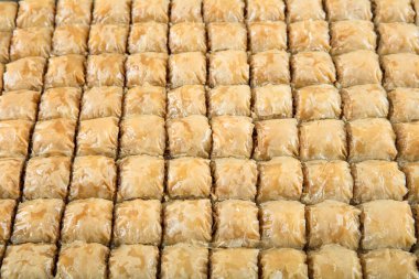 Geleneksel Türk tatlıları; el yapımı ceviz baklavası. Türkçe adı: cevizli baklava. Ahşap zemin üzerinde ceviz baklava. Türk tarzı ceviz baklavası sunumu ve hizmeti.