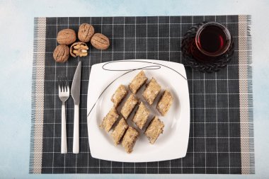 Geleneksel Türk tatlıları; el yapımı ceviz baklavası. Türkçe adı: cevizli baklava. Ahşap zemin üzerinde ceviz baklava. Türk tarzı ceviz baklavası sunumu ve hizmeti.