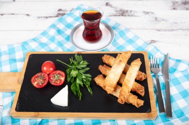 Sigara böreği. Ahşap zeminde peynirli turta. Kızarmış peynirli rulo sandviç. Yerel adı sigara boregi. Türk Purosu Şekilli Rolls. Ispanaklı ve peynirli Türk çorbası..