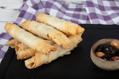 Sigara böreği. Ahşap zeminde peynirli turta. Kızarmış peynirli rulo sandviç. Yerel adı sigara boregi. Türk Purosu Şekilli Rolls. Ispanaklı ve peynirli Türk çorbası..