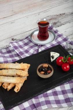 Sigara böreği. Ahşap zeminde peynirli turta. Kızarmış peynirli rulo sandviç. Yerel adı sigara boregi. Türk Purosu Şekilli Rolls. Ispanaklı ve peynirli Türk çorbası..