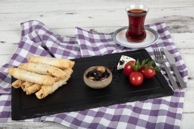 Sigara böreği. Ahşap zeminde peynirli turta. Kızarmış peynirli rulo sandviç. Yerel adı sigara boregi. Türk Purosu Şekilli Rolls. Ispanaklı ve peynirli Türk çorbası..