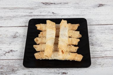 Sigara böreği. Ahşap zeminde peynirli turta. Kızarmış peynirli rulo sandviç. Yerel adı sigara boregi. Türk Purosu Şekilli Rolls. Ispanaklı ve peynirli Türk çorbası..