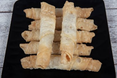 Sigara böreği. Ahşap zeminde peynirli turta. Kızarmış peynirli rulo sandviç. Yerel adı sigara boregi. Türk Purosu Şekilli Rolls. Ispanaklı ve peynirli Türk çorbası..