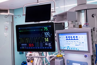 Monitörde kan basıncı ve nabız atışı görünüyor. Hastanın hayati belirtilerini gösteren bir monitörle birlikte monitör ve tıbbi makine ameliyat odası ekipmanları..