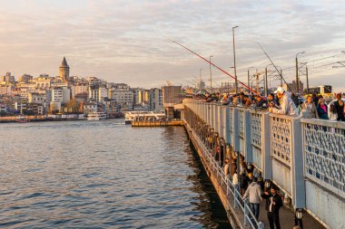 İstanbul, Türkiye, 13 Nisan 2025, Galata Köprüsü 'nde balık tutan insanlar. İstanbul, Türkiye 'de Sokak Gıda Tedarikçileri, Balıkçılar ve Galata Kulesi Manzaralı Galata Köprüsü.