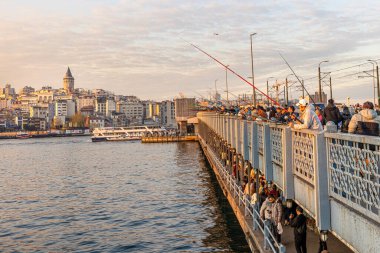 İstanbul, Türkiye, 13 Nisan 2025, Galata Köprüsü 'nde balık tutan insanlar. İstanbul, Türkiye 'de Sokak Gıda Tedarikçileri, Balıkçılar ve Galata Kulesi Manzaralı Galata Köprüsü.